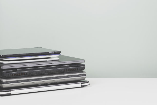 白色的桌子上堆放着一堆要回收的旧笔记本电脑。计划报废，电子废物，电子废物再利用和回收概念图片下载