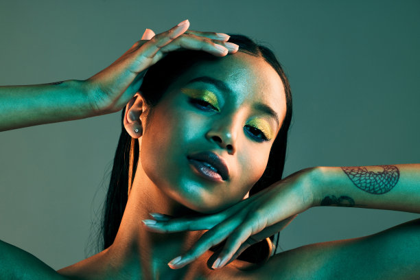 一个美丽的女人在一个绿色的背景下摆姿势图片下载