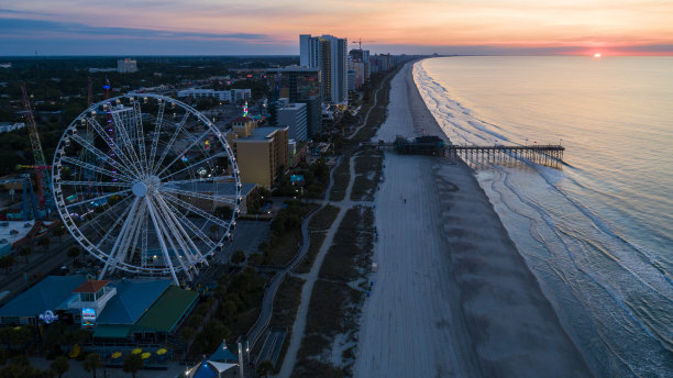 日出时分，南卡罗来纳默特尔比奇游乐园里的摩天轮。图片下载
