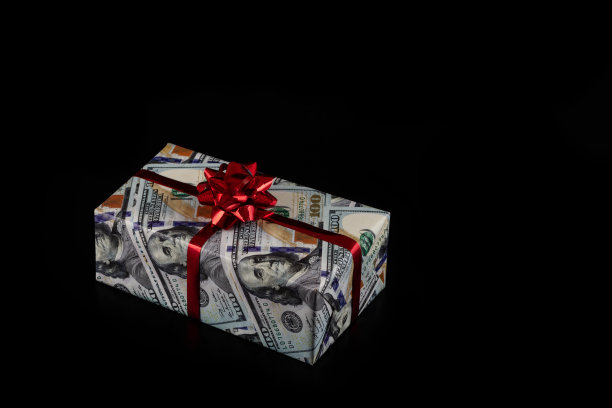 孤立的礼盒包装在包装纸与100美元的图片在黑色背景图片下载
