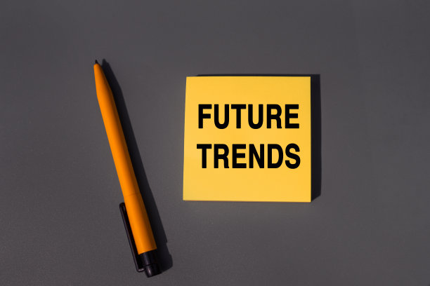 未来趋势-写在便利贴上的单词。概念最新，最新，热门和流行的未来趋势。个人议程的特写。橙色方块便签和笔在灰色背景，顶视图图片下载