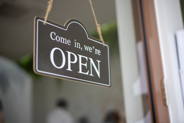 咖啡店前面的牌子上写着“请进，我们开门”。图片下载