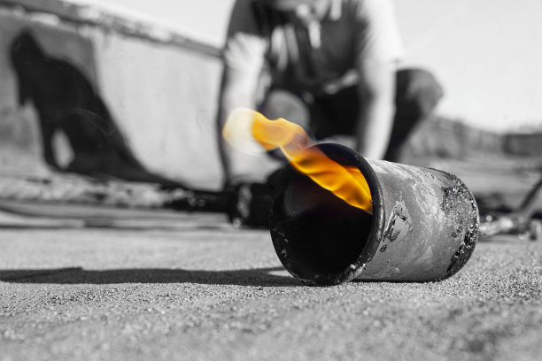 软屋顶的弹簧修复与滚动材料使用燃气燃烧器，前面和背景是模糊的散景效果图片下载