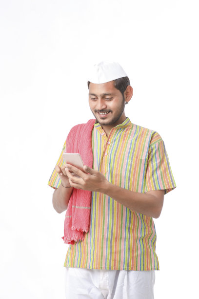 年轻的印度农民在白色背景下使用智能手机。图片下载