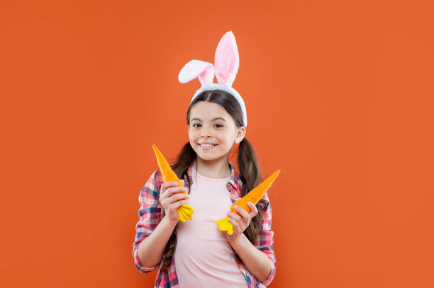 感觉兴奋。快乐的少女戴着兔耳朵。复活节快乐。童年的幸福。图片下载