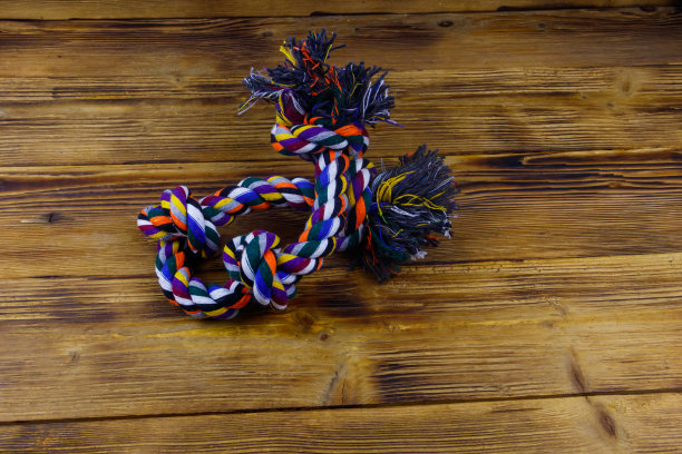 木制背景上的彩色绳子玩具狗图片下载