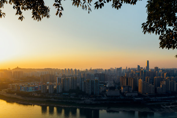 日落时分，这座城市在河岸边。这是中国的重庆图片下载