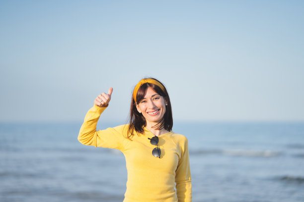 女人在海边竖起大拇指表示没事图片下载