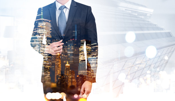 身着黑色西装的商人站在摩天大楼和散景灯光的背景下图片下载