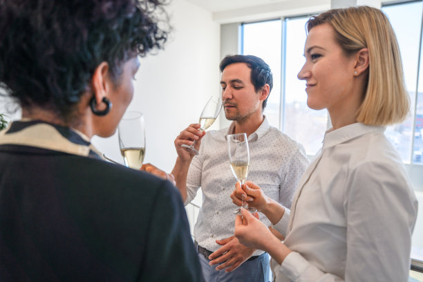 在办公室聚会上享用香槟的男女高管图片下载