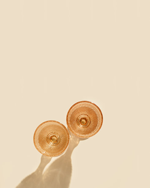 两个葡萄酒杯由淡粉色玻璃与阳光的硬阴影，创意夏季饮品最小概念，白色葡萄酒杯在高脚杯风格上桃色背景，copyspace图片下载