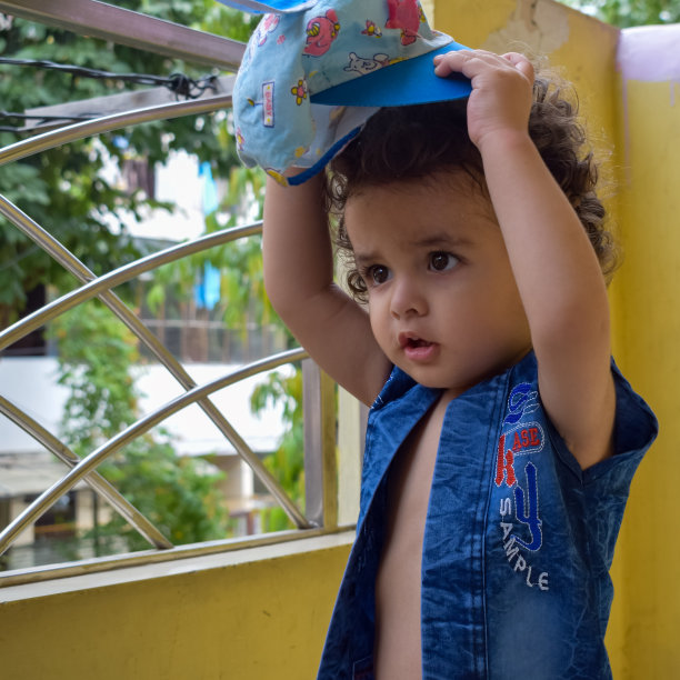 可爱的小男孩Shivaay在夏天的时候在家里的阳台上，可爱的小男孩在白天拍摄照片，小男孩在家里享受拍摄照片图片下载