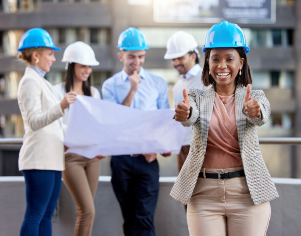 一名年轻的女建筑师在与同事们在城市背景下工作时竖起了大拇指图片下载