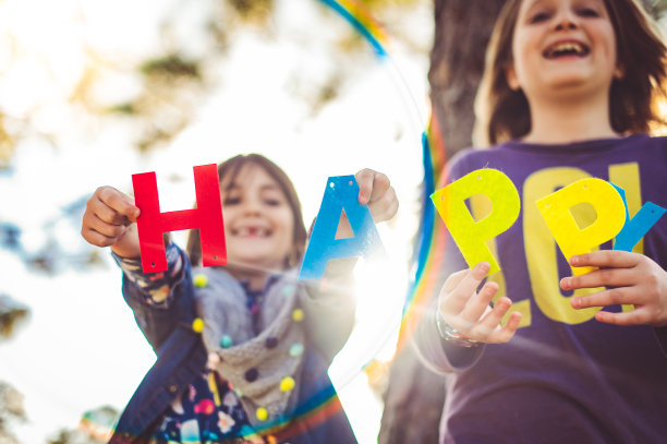 可爱的微笑的孩子举起字母拼写“快乐”快乐和友谊图片下载