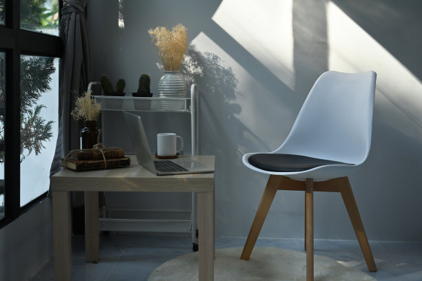 一张舒适的工作空间的照片，周围是一个木制的桌子，电脑笔记本电脑，咖啡杯，旧书，仙人掌和椅子。图片下载