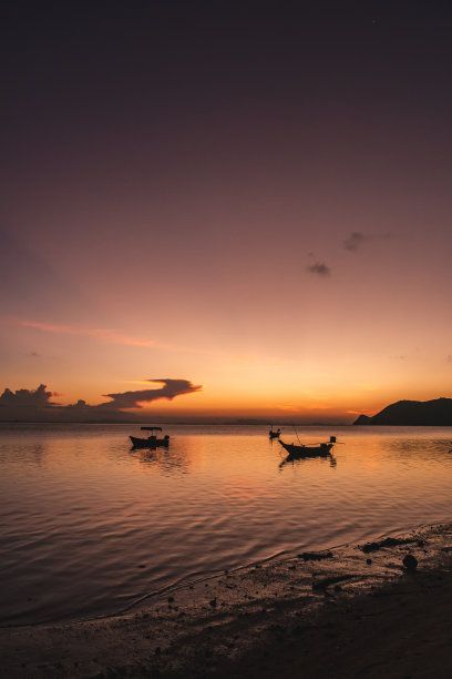 夕阳西下，海上渔船的剪影图片下载