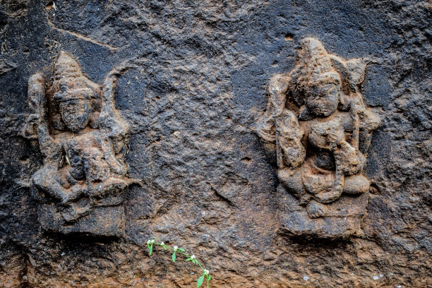 灰色的石墙上雕刻着印度教神的古代遗址雕塑的库存照片。这张照片是在印度马哈拉施特拉邦科尔哈布尔阳光明媚的一天拍摄的。关注对象。图片下载