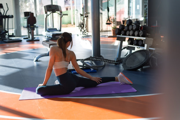 有吸引力的女人在运动服装练习高级瑜伽练习体位在健身房，股票照片图片下载