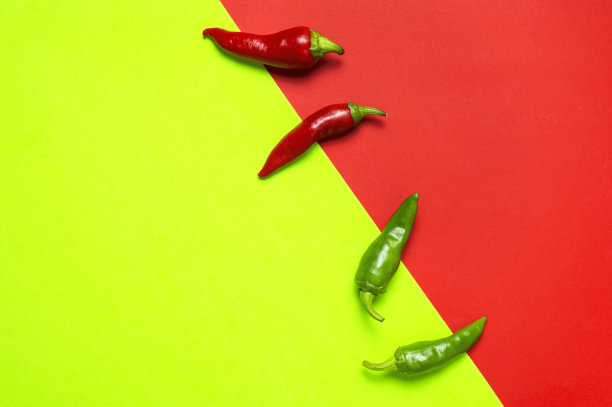 热的红色和绿色的新鲜辣椒辣椒红绿色背景平躺顶视图。菜肴调味料，烹饪用辛辣香料，辣椒，食物。创意布局，辣椒图案图片下载