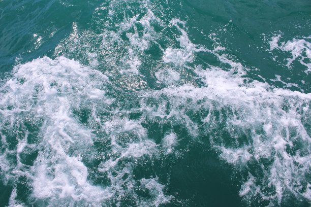 从海上的小船上留下的尾流。船上的痕迹。特写镜头。背景。纹理。图片下载