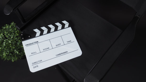 拍板或拍板或电影板与导演椅子使用在视频制作，电影，电影行业的黑色背景。图片下载