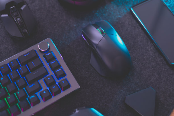 游戏玩家的工作空间概念，俯视图一个游戏装备，鼠标，键盘，操纵杆，耳机，移动操纵杆，耳机和鼠标垫在黑色的桌面背景上。图片下载