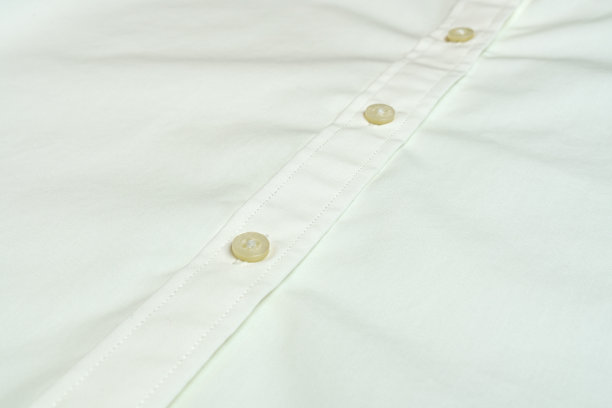 一个带纽扣的白色棉女衬衫的碎片。优质易熨烫面料。有选择性的重点。图片下载