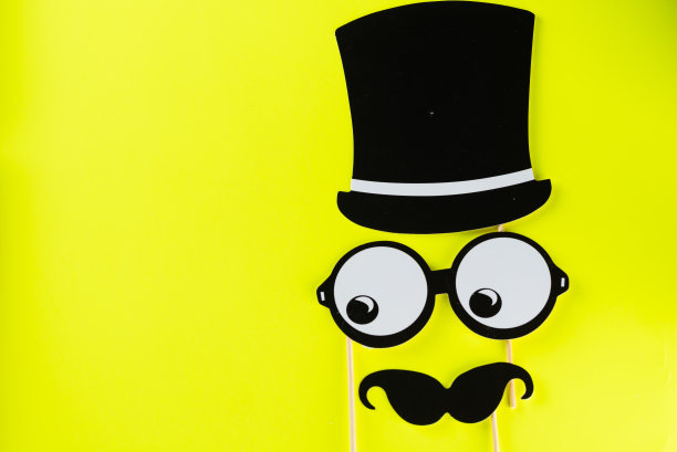 黄色背景上的滑稽面具俯视图图片下载