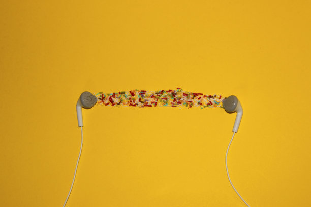 白色耳机黄色背景结合彩色装饰糖美丽的内容从他们的羽毛和眼睛和耳朵图片下载