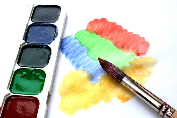 水彩颜料和绘画用的画笔在一张白布上图片下载