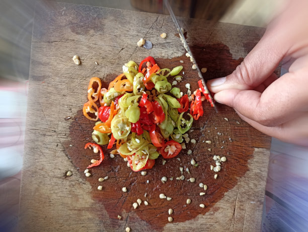 在木板上切辣椒的人。图片下载