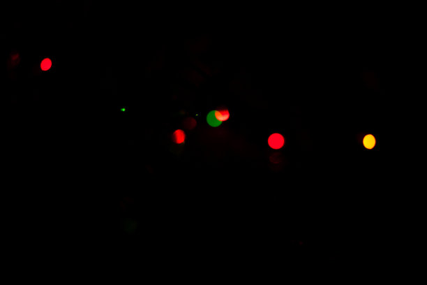 散焦的黑暗背景与彩色圣诞灯散景效果图片下载