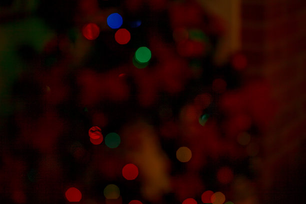 散焦的黑暗背景与彩色圣诞灯散景效果图片下载