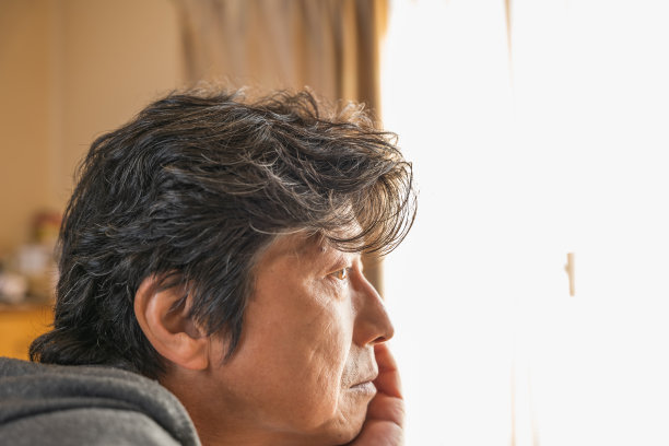 在卧室的窗户边有个满脸烦恼的中年男人图片下载