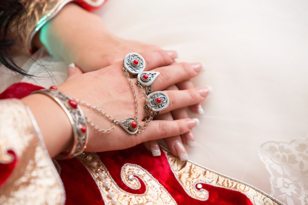 两枚金婚戒和白色背景上的玫瑰花。水平框中的图片。两枚结婚戒指和一张结婚请柬图片下载