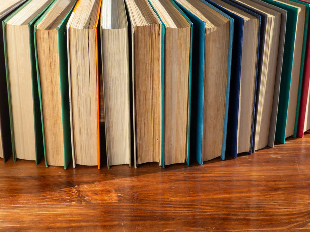 木桌上放着书页发黄的精装书。图片下载