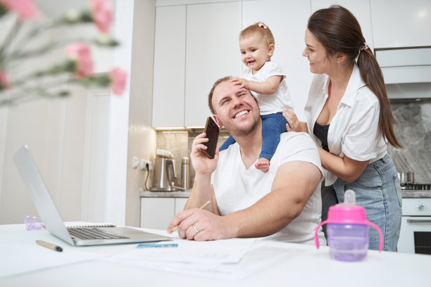 笑的男人拿着智能手机，脖子上还挂着婴儿图片下载