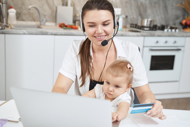 让宝宝在家工作时使用笔记本电脑的女人图片下载