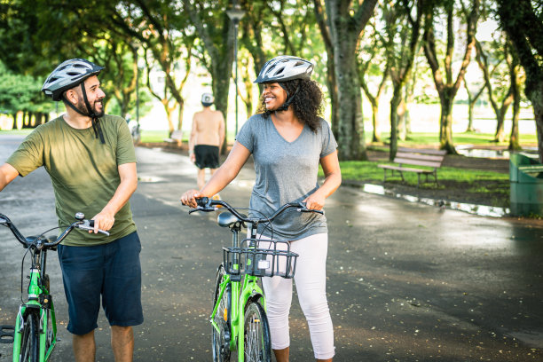 两个好朋友骑着自行车在公园里聊天图片下载