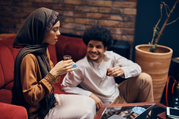 一名年轻的中东妇女在咖啡馆用笔记本电脑喝土耳其茶。图片下载