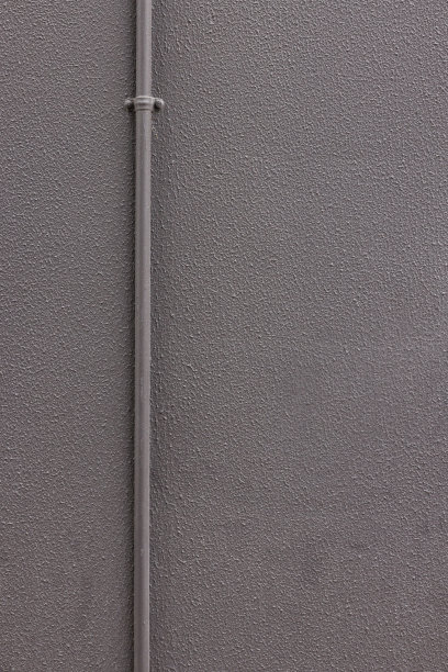 金属管道沿着灰色粉刷的墙壁图片下载