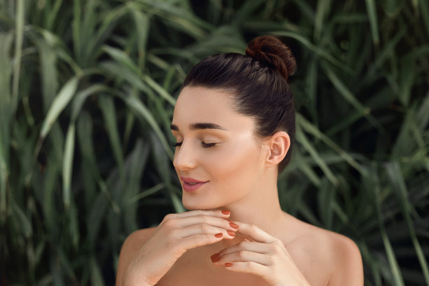 美丽的概念。美丽的女人模型与完美的清洁皮肤。热带树叶中的女孩的肖像。身体和皮肤护理。图片下载