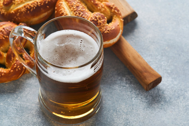 巴伐利亚椒盐卷饼和大杯啤酒。啤酒节的食物菜单，浅灰色背景上的传统咸椒盐卷饼。顶部视图与文本的空间。啤酒节的主题图片下载