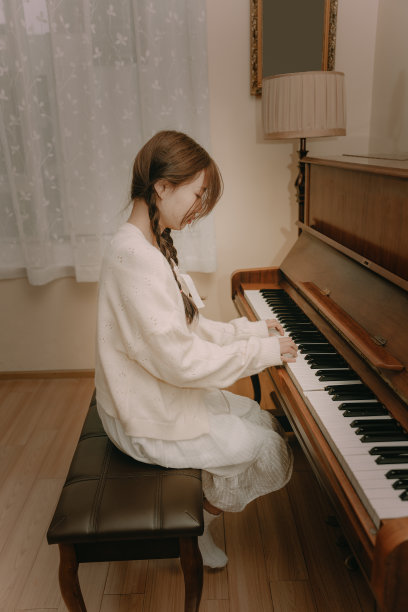 一个美丽的亚洲女孩弹钢琴图片下载