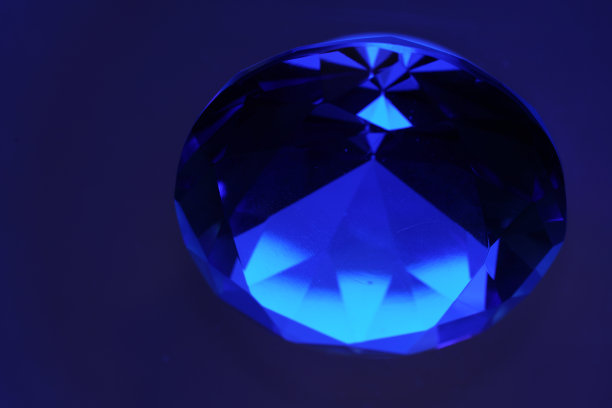 明亮的切割绿色钻石拍摄在工作室与彩色背景图片下载