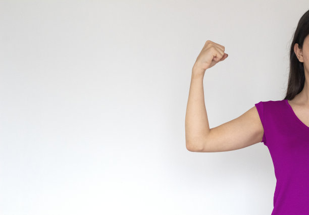 女人举起手，露出肌肉。空间fot文本。strog女人背景图片下载