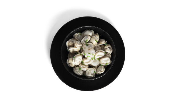 白色底色上点缀着牛肉和葱花的饺子图片下载