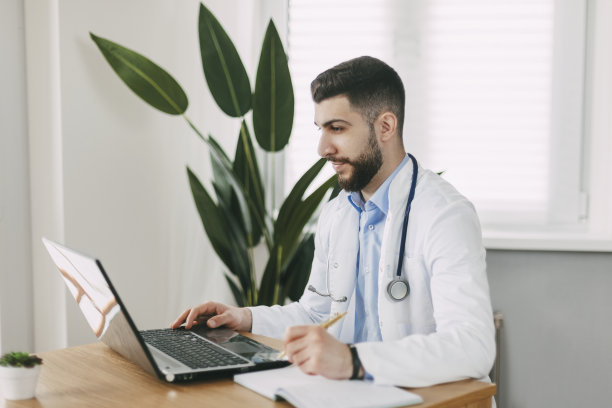年轻的男医生正在办公室用笔记本电脑进行在线视频咨询图片下载