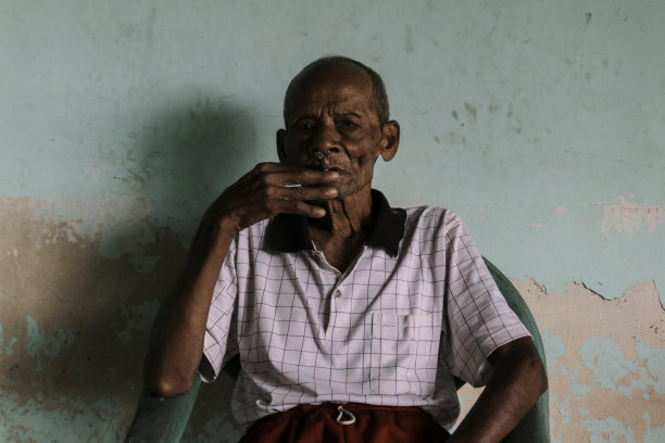 亚洲爪哇老人的特写肖像，手里拿着一支香烟图片下载