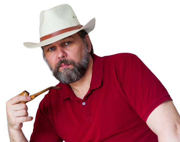 一个留着胡子的中年男子，戴着一顶白色的宽边帽，手里拿着烟斗，孤零零地站在白色的地上。一个戴着牛仔帽的男人。一位留着灰胡子的中年男子正看着我们。图片下载